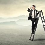 businessman-ladder-using-binoculars-desert